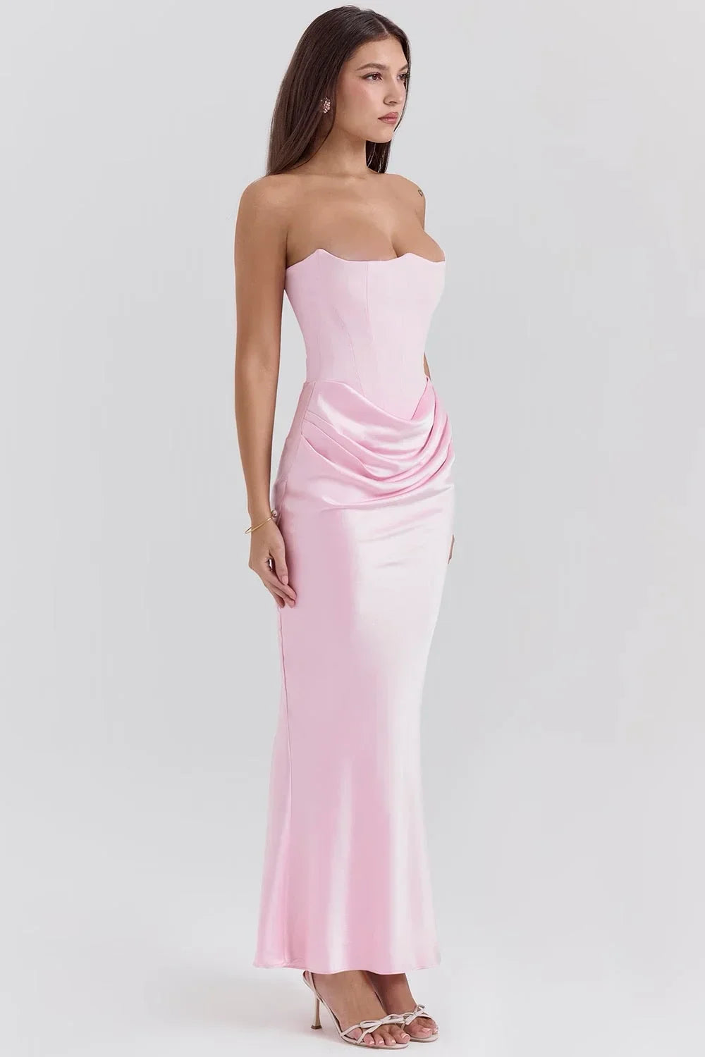 Robe longue rose sans bretelles en satin drapé avec bustier, offrant un look fluide et élégant pour toutes les occasions.