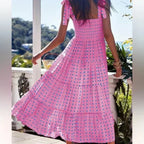 Robe longue rose smockée avec bretelles nouées, fabriquée en coton léger, idéale pour l'été avec un imprimé floral.