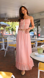 Robe longue rose à volants avec liens, fabriquée en coton léger, idéale pour un été confortable et stylé.