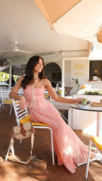 Robe longue rose à volants, en coton léger, avec des liens ajustables, parfaite pour les journées d'été décontractées.