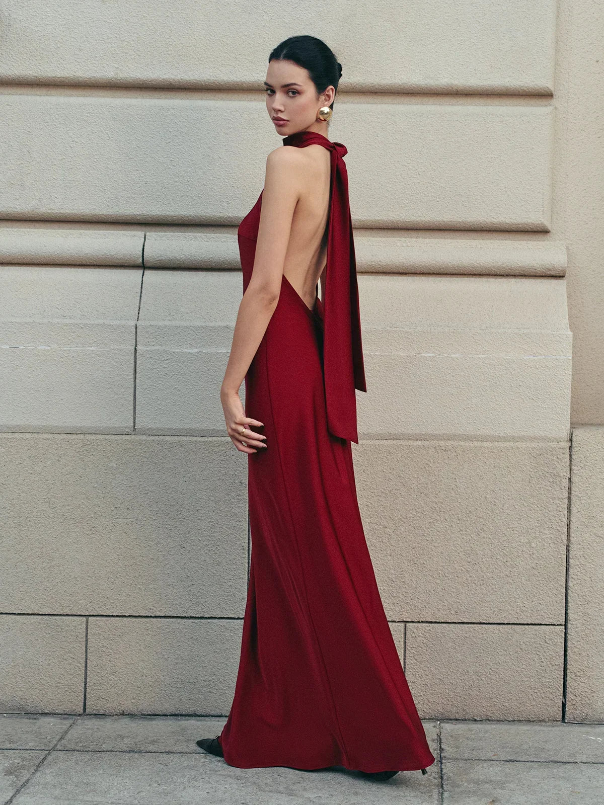 Robe longue rouge en satin, dos nu, avec un nœud traînant, parfaite pour les soirées élégantes et les occasions spéciales.