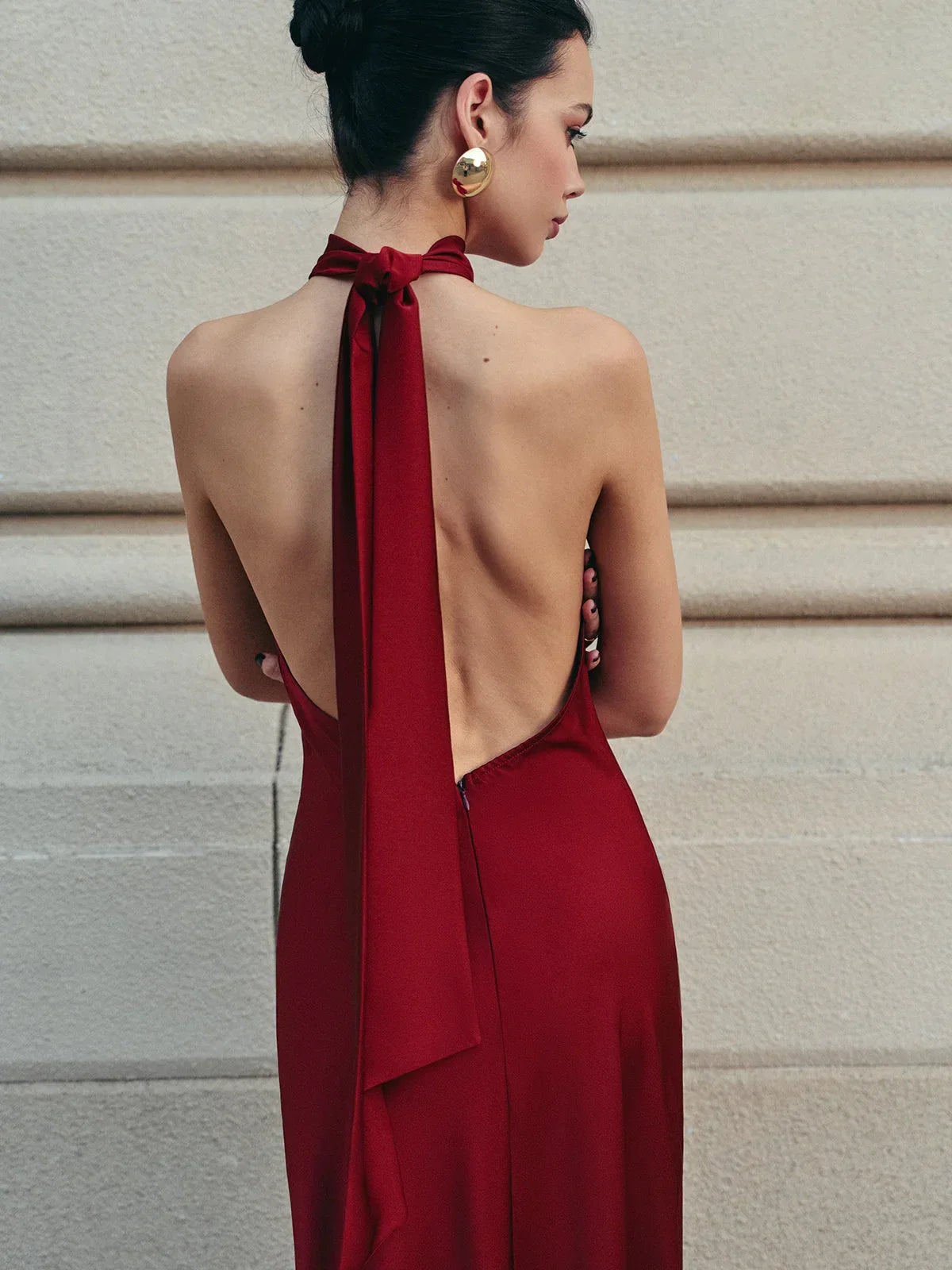 Robe longue rouge, dos nu avec nœud traînant, tissu satin fluide et design élégant pour soirées.