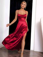 Robe longue rouge en satin avec bretelles fines, fente élégante, idéale pour une soirée ou un événement spécial.