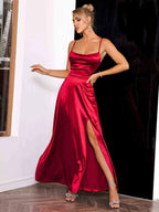 Robe longue rouge satinée à bretelles fines avec fente, offrant une allure élégante et fluide pour les soirées.