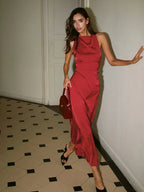 Robe longue rouge satinée sans manches, avec une fente sur le côté pour une silhouette élégante et fluide.