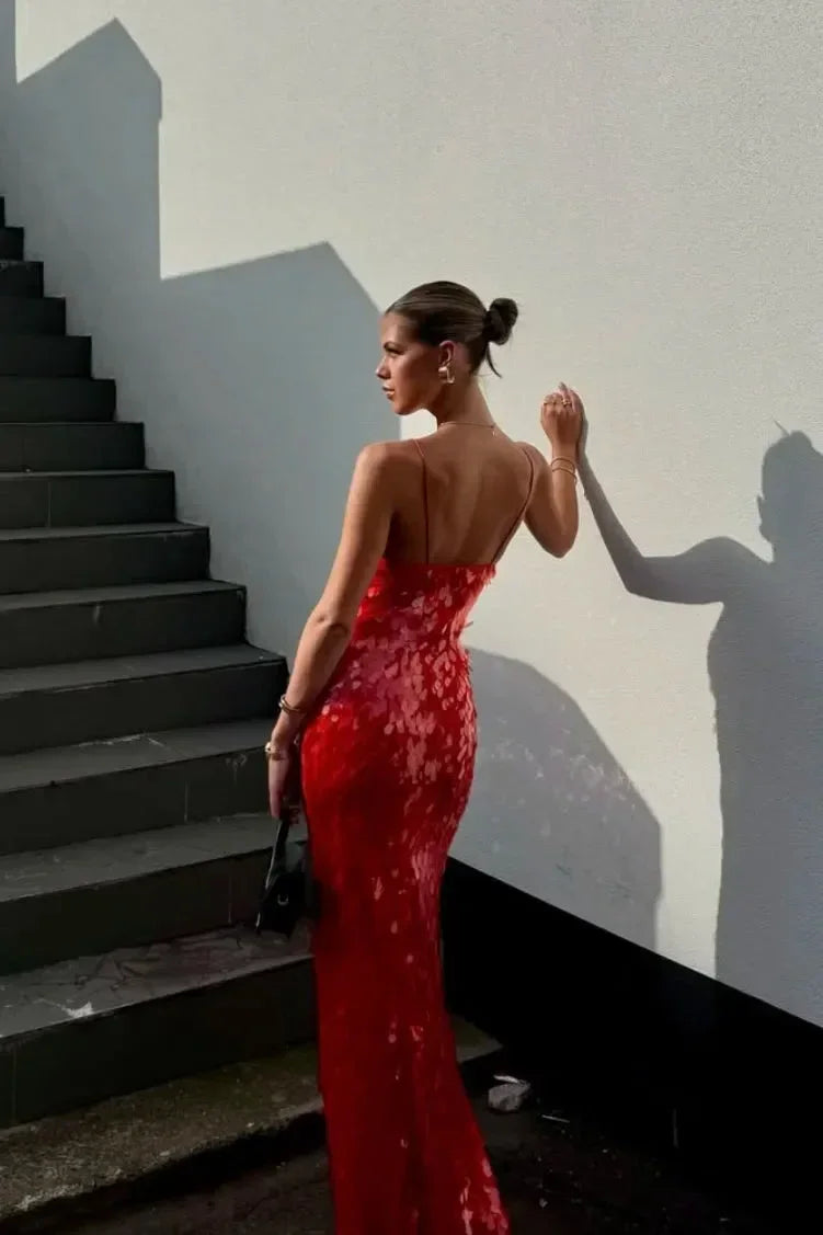 Robe longue rouge à sequins, décolleté plongeant, sans manches, en tissu scintillant, idéale pour les soirées élégantes.