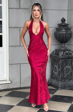 Robe longue rouge à col licou, en tissu fluide, avec nœud à la taille, idéale pour les soirées élégantes.