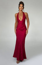 Robe longue rouge en tissu léger, col licou avec nœud, idéale pour les soirées élégantes, silhouette fluide et moderne.