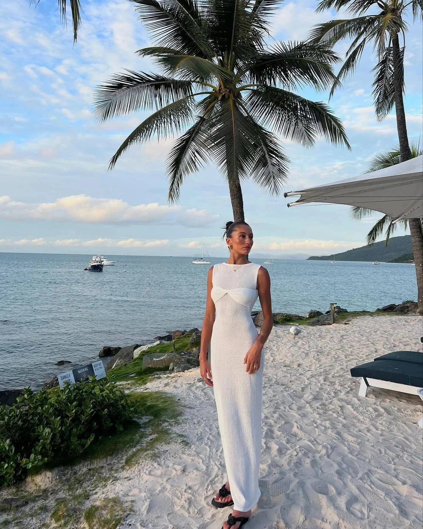 Robe longue sans manches en tissu léger avec détail torsadé, idéale pour un look décontracté à la plage cet été.