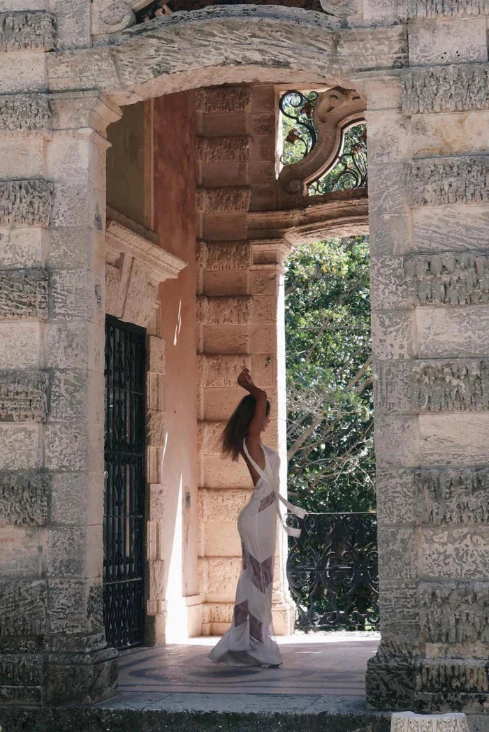 Robe longue sans manches en dentelle, dos nu, conçue en tissu léger et floral, parfaite pour les soirées élégantes.