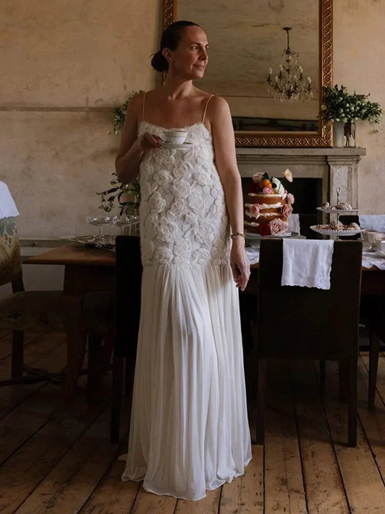 Robe longue sans manches en dentelle avec fines bretelles, tissu léger et fluide, idéale pour les soirées élégantes.