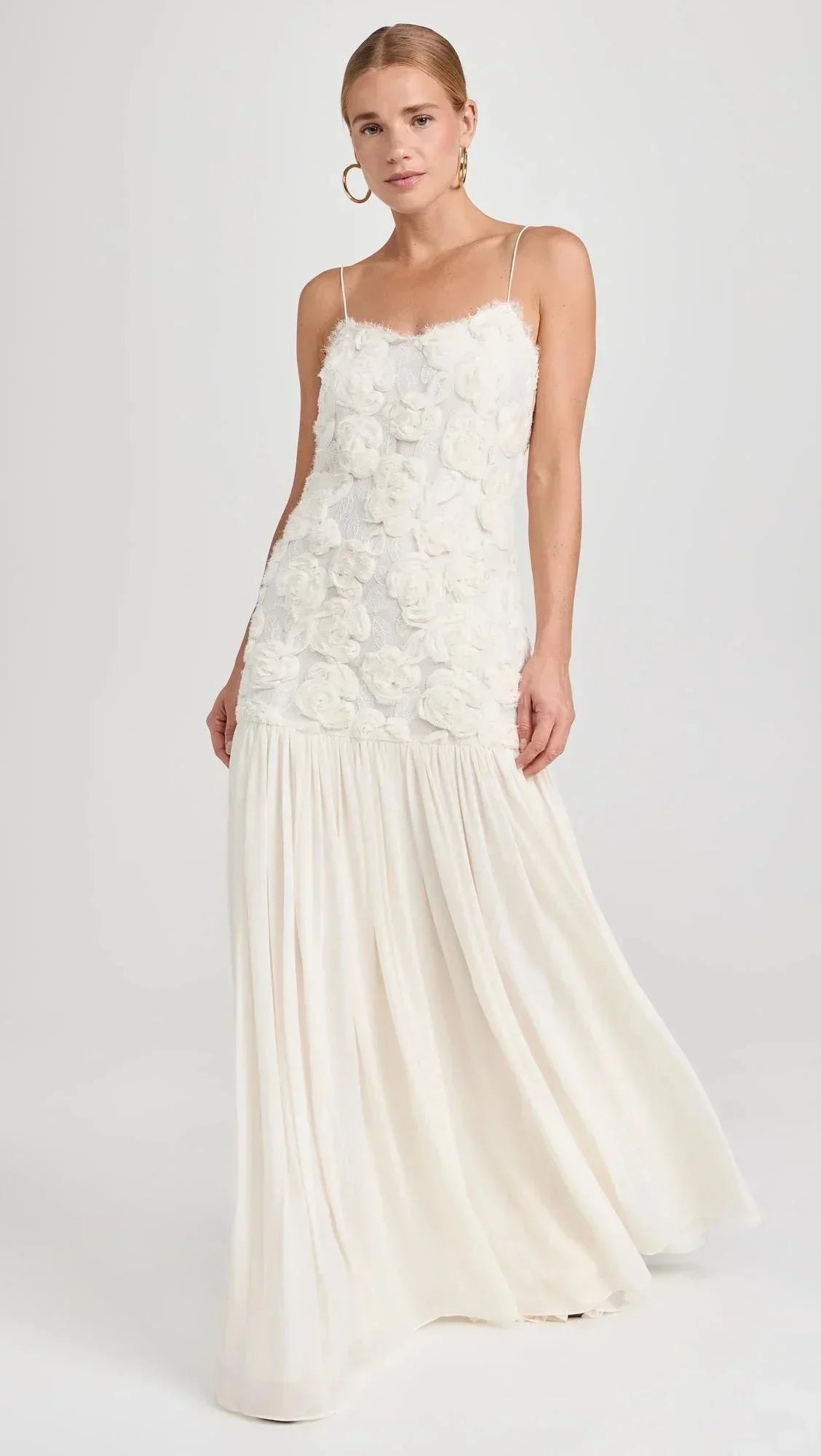 Robe longue sans manches en dentelle, fines bretelles et design fluide, parfaite pour les soirées élégantes.