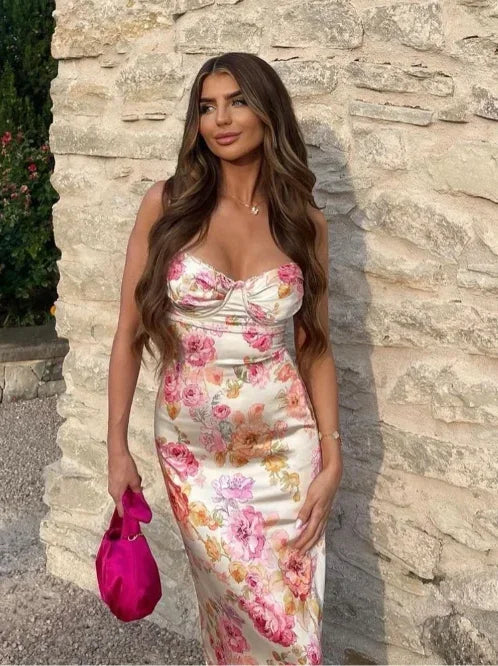 Robe longue satinée rose avec fleurs, coupe ajustée, sans manches et décolleté en cœur, idéale pour les soirées d'été.