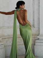 Robe longue satinée à une épaule, avec détails de cape, idéale pour des soirées élégantes. Matière fluide et design chic.