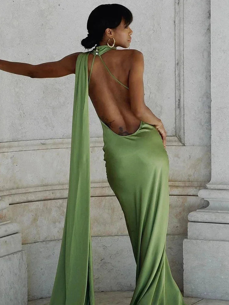 Robe longue satinée à une épaule, avec détails de cape, idéale pour des soirées élégantes. Matière fluide et design chic.