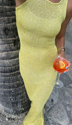 Robe longue scintillante sans manches, en tissu fluide avec encolure plongeante, parfaite pour les soirées élégantes.