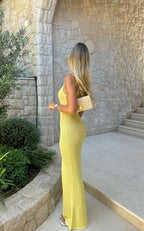 Robe longue sans manches en tissu scintillant, avec encolure plongeante, idéale pour des soirées élégantes.