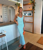 Robe longue scintillante sans manches, en tissu léger, avec une encolure plongeante et un design élégant, idéale pour les…