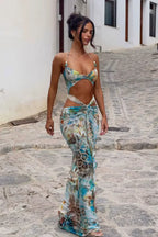 Robe longue turquoise à fleurs, en tissu léger, avec découpes estivales et bretelles fines pour un look décontracté.