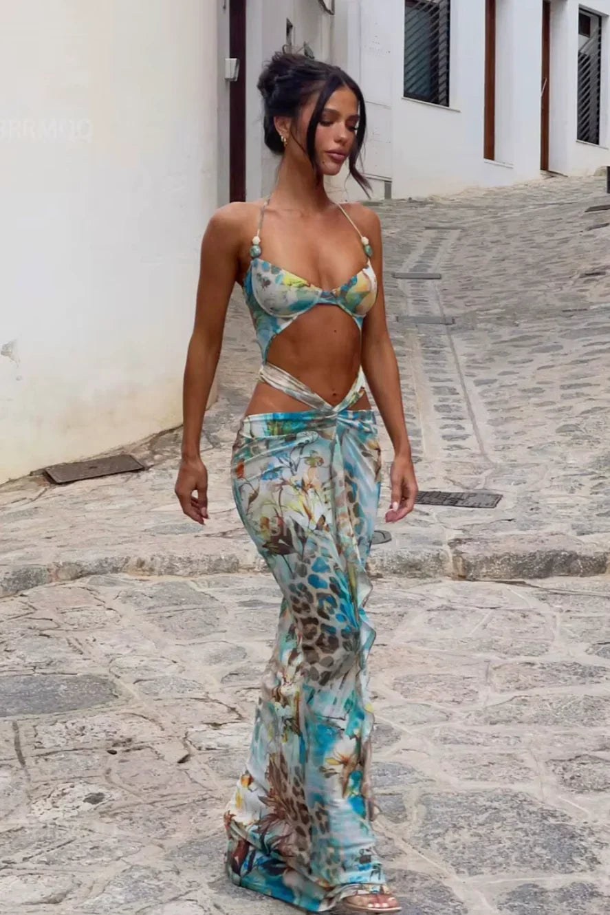 Robe longue turquoise à fleurs, en tissu léger, avec découpes estivales et bretelles fines pour un look décontracté.