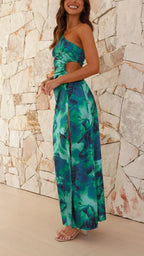 Robe longue verte à une épaule, fente latérale, en tissu léger, ornée d'un imprimé floral coloré.