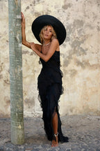 Robe longue asymétrique en tissu léger avec volants et bretelles ajustables, idéale pour une soirée élégante.