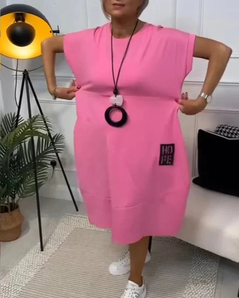 Robe midi ample en tissu fluide, manches courtes, poches pratiques, idéale pour un look décontracté en toutes saisons.