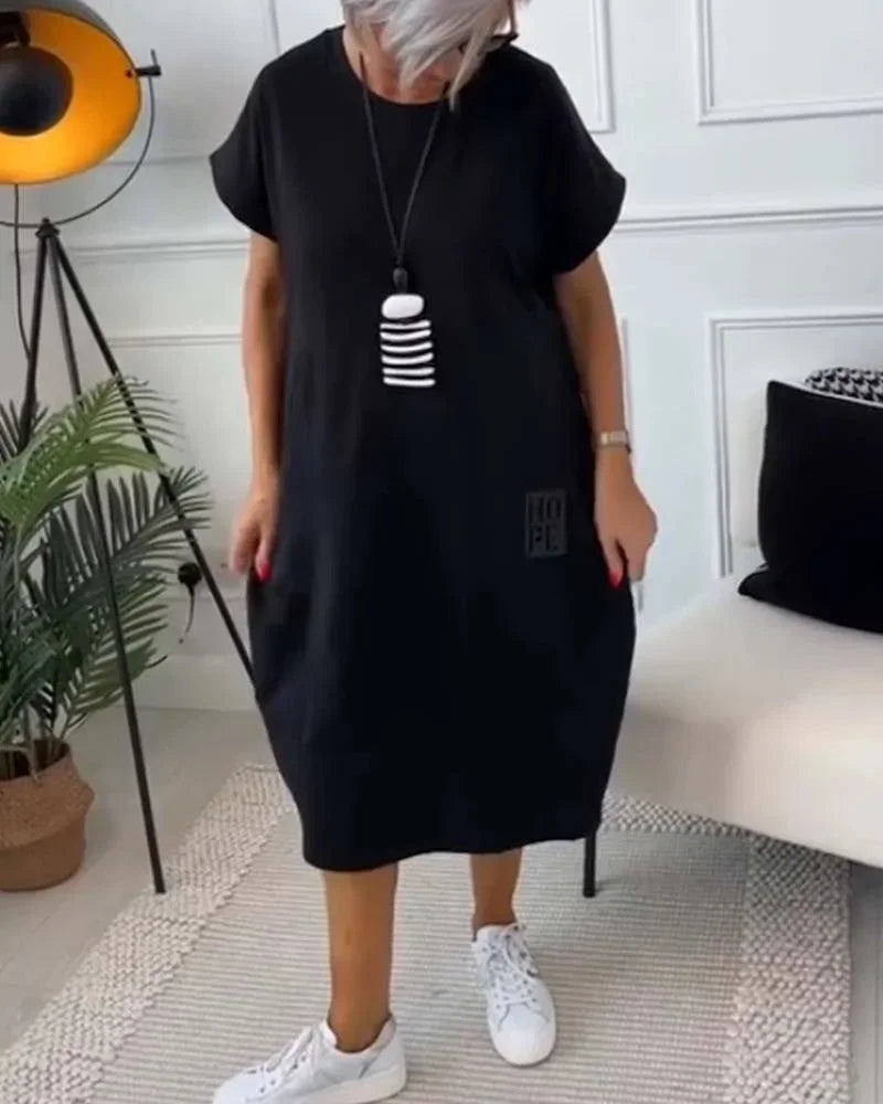 Robe midi ample en tissu fluide, manches courtes, style décontracté et poches pratiques, idéale pour toutes les saisons.