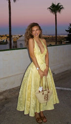 Robe midi jaune à dos nu, jupe plissée en tissu léger, idéale pour les soirées d'été élégantes et décontractées.