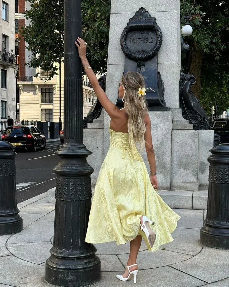 Robe midi jaune à dos nu, jupe plissée en tissu léger, idéale pour les soirées d'été.