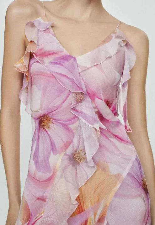 Robe midi asymétrique en tissu léger avec volants et motifs de fleurs roses, idéale pour les soirées d'été.