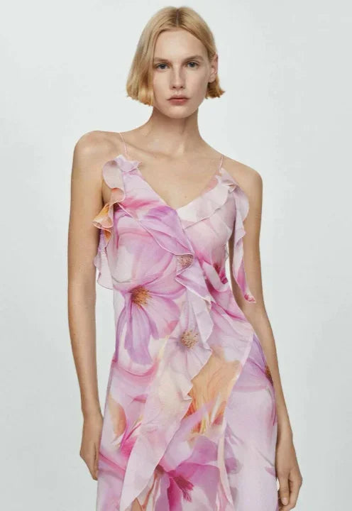 Robe midi asymétrique en tissu léger avec volants et motifs floraux roses, parfaite pour les soirées estivales.