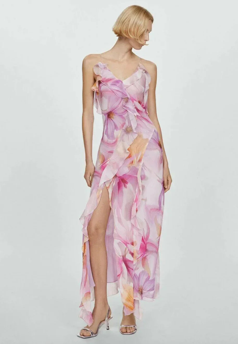 Robe midi asymétrique en tissu léger, ornée de volants et imprimé floral rose, idéale pour les soirées d'été.