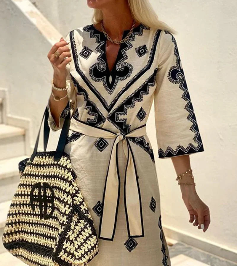 Robe midi beige à imprimé, ceinture à la taille, manches 3/4 et col en V, idéale pour un look décontracté d'été.
