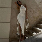 Robe midi blanche asymétrique sans manches avec col licou et volants, en tissu fluide pour un look estival élégant.