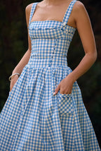 Robe midi bleu à carreaux vichy, épaules dénudées, en tissu léger idéal pour l'été. Design intemporel et confortable.