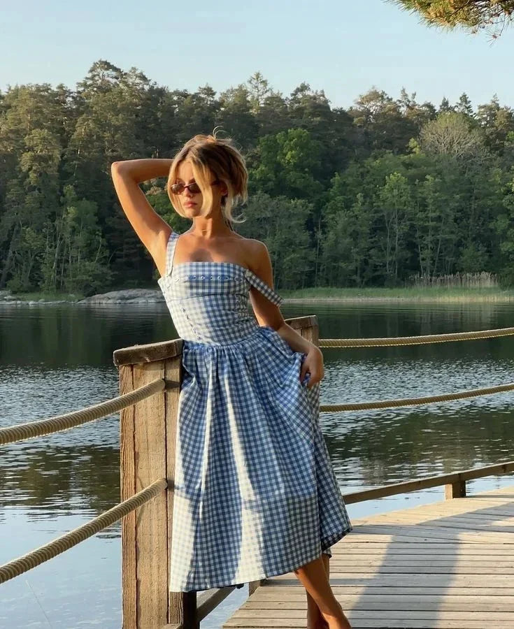 Robe midi bleue à carreaux vichy, épaules dénudées, en tissu léger, idéale pour les journées d'été.