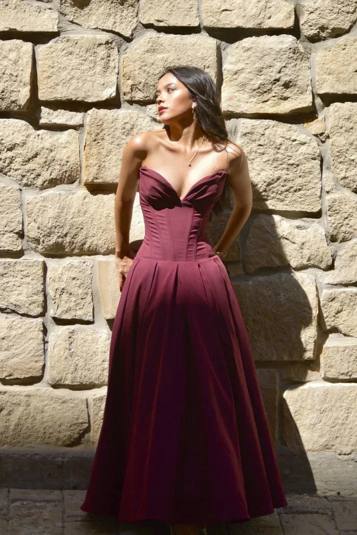 Robe midi bustier en satin noir, corset ajusté, coupe évasée, idéale pour les soirées avec un style élégant.