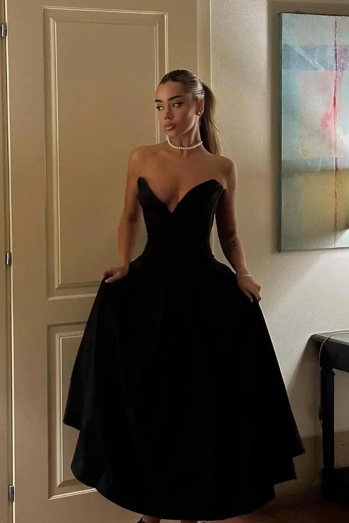 Robe midi bustier en tissu fluide, corset ajusté et jupe évasée, idéale pour des soirées élégantes.