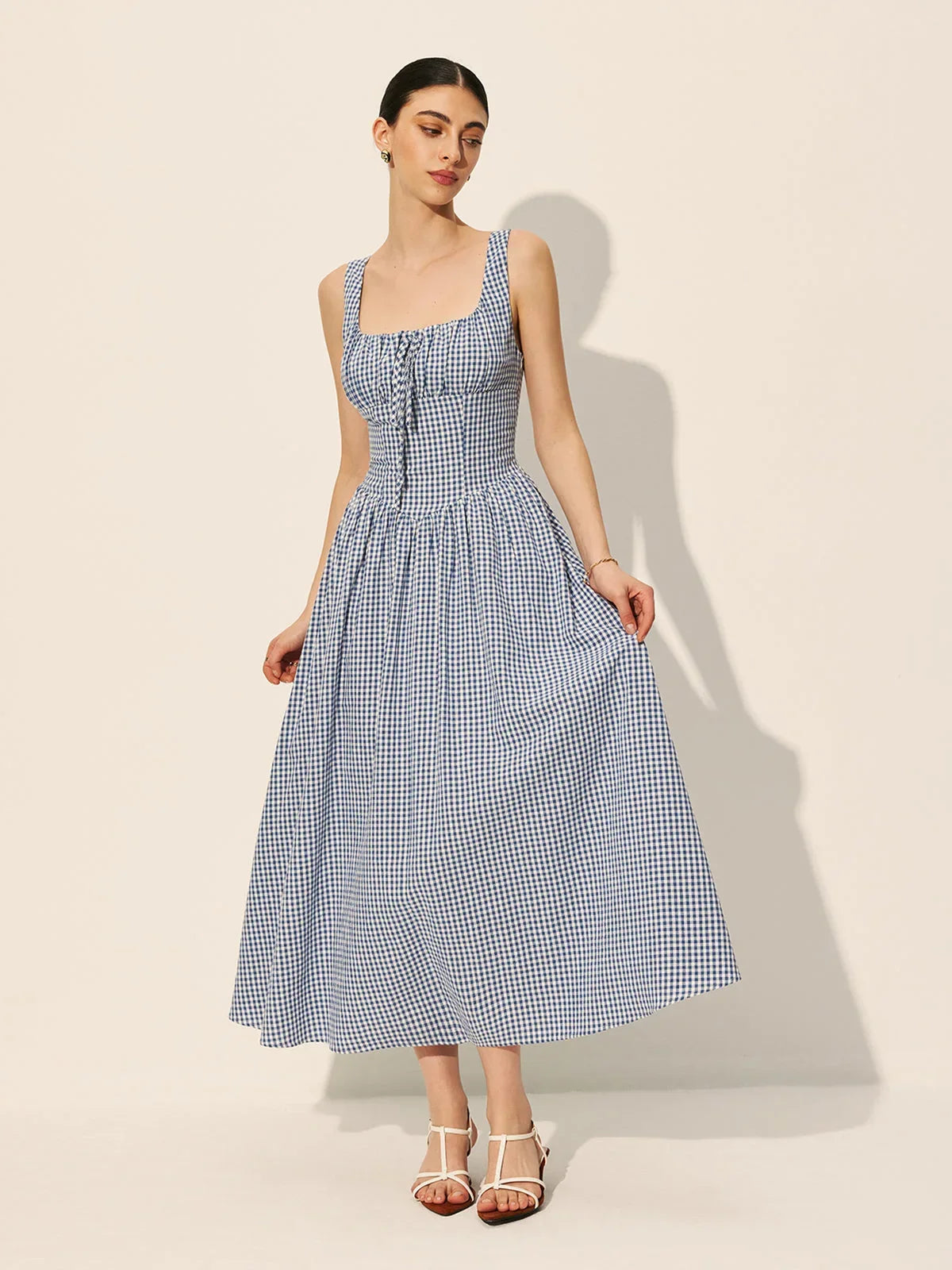 Robe midi sans manches en tissu léger à carreaux bleu marine, col carré, idéale pour un look décontracté d'été.