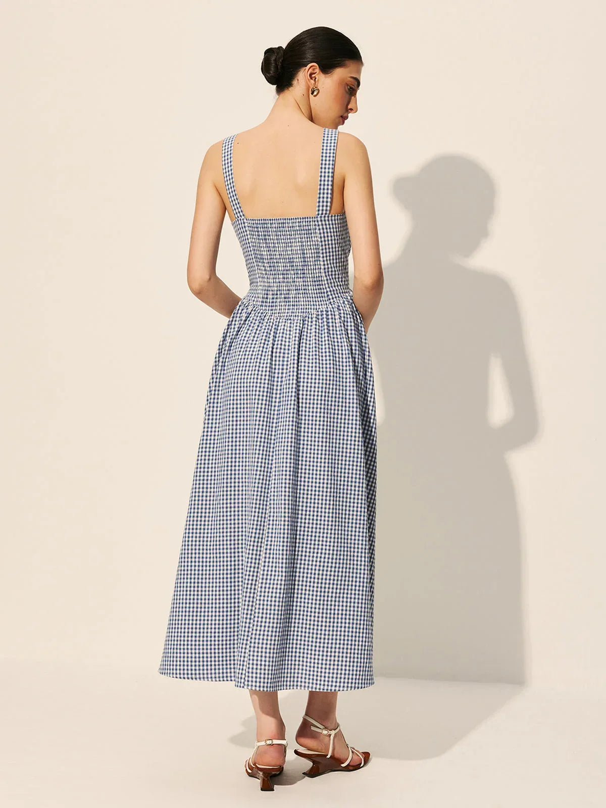Robe midi sans manches à carreaux bleu marine, col carré, en tissu léger, idéale pour un été décontracté.