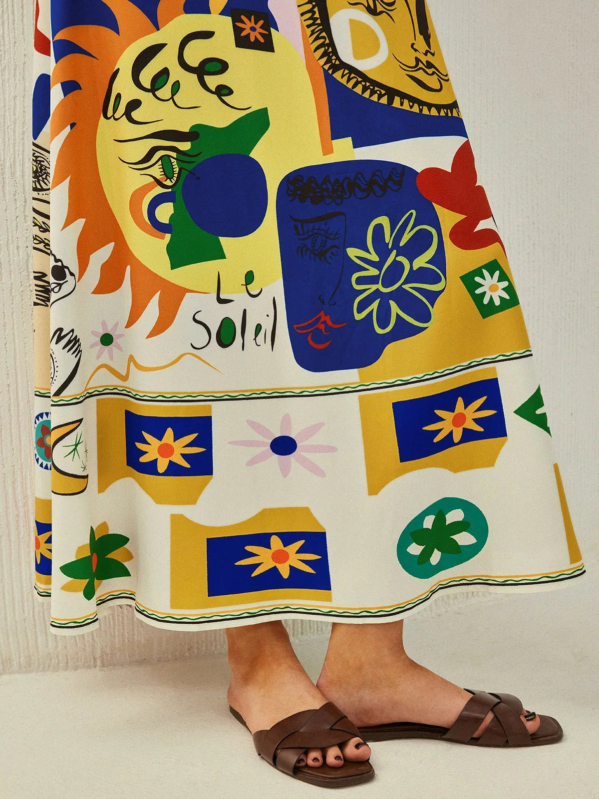 Robe midi colorée avec motifs ludiques, bretelles fines, en tissu fluide pour un confort et un style décontracté.