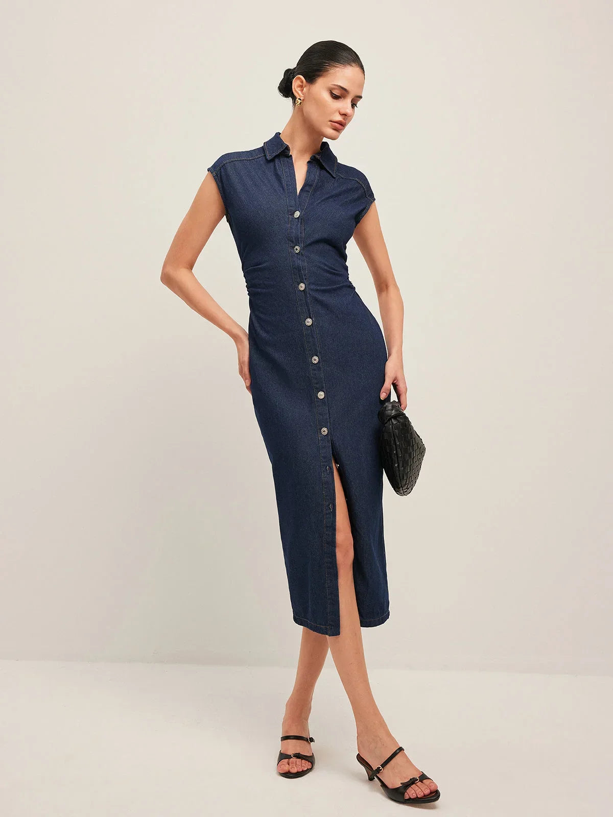Robe midi en jean bleu foncé, sans manches, col V avec boutons, idéale pour un style décontracté et confortable.