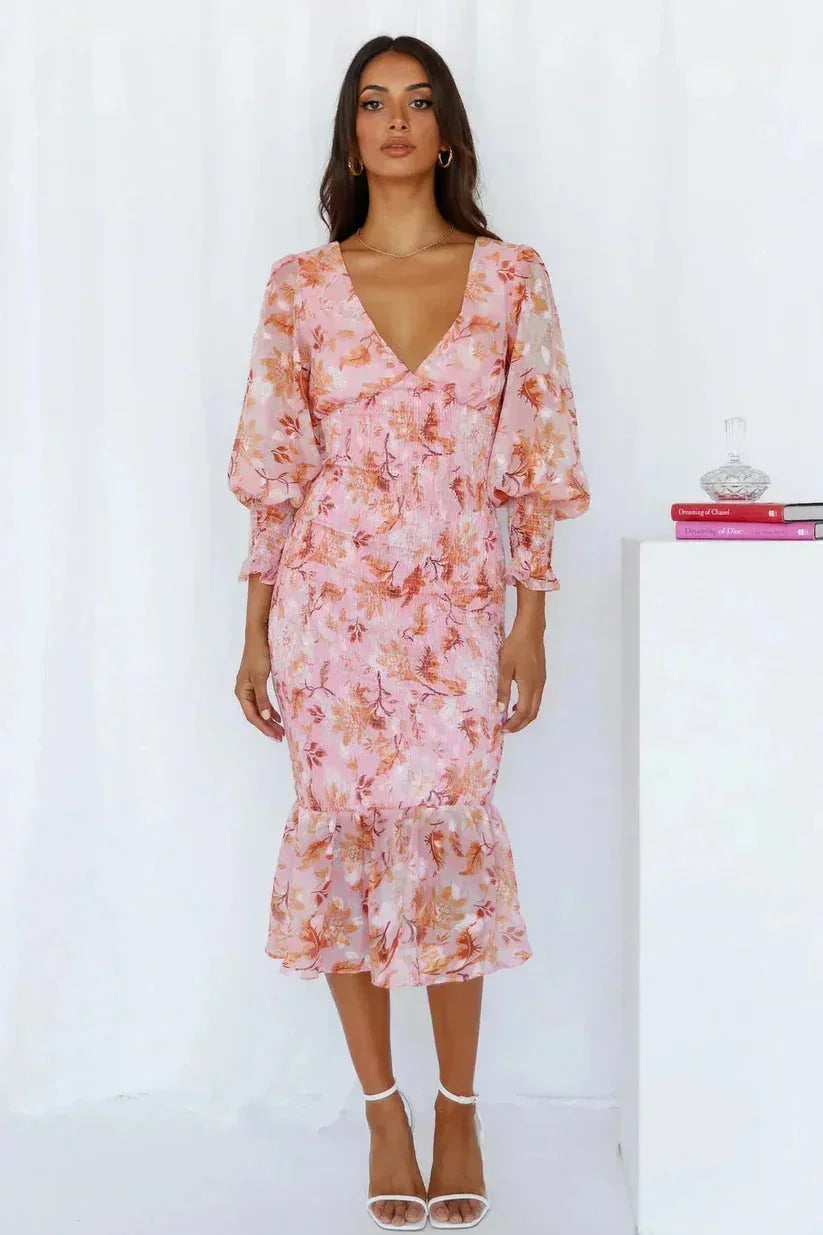 Robe midi fluide à fleurs avec manches longues, col en V et ourlet évasé, parfaite pour une tenue décontractée.