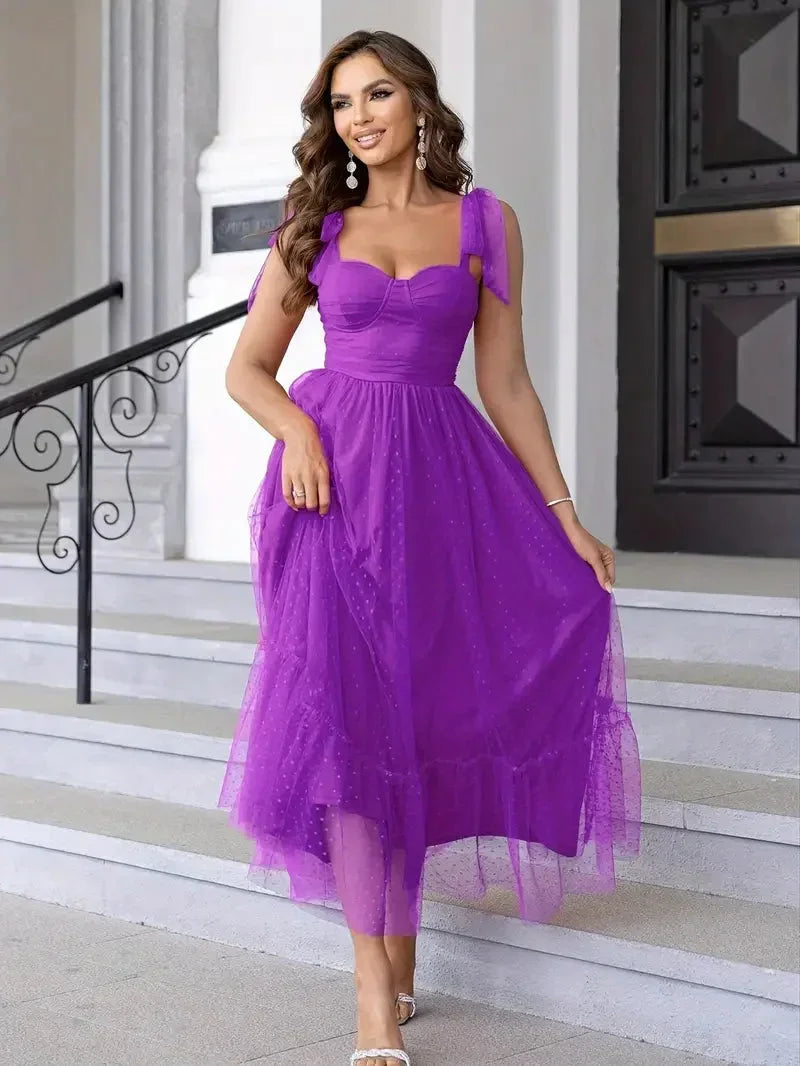 Robe midi sans manches en mesh, ornée de nœuds sur les épaules, idéale pour une tenue décontractée ou estivale.