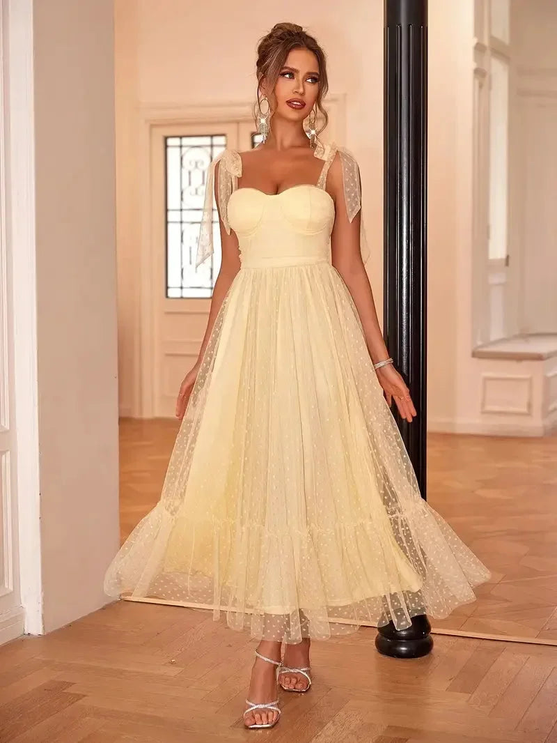 Robe midi femme sans manches en mesh, avec nœuds décoratifs sur les épaules pour un style léger et aérien.