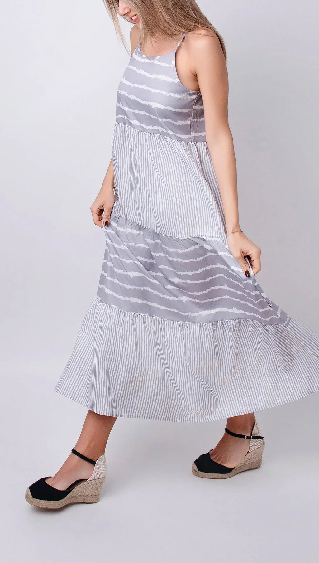 Robe midi grise sans manches avec volants, en tissu léger parfait pour l'été, design fluide et élégant.