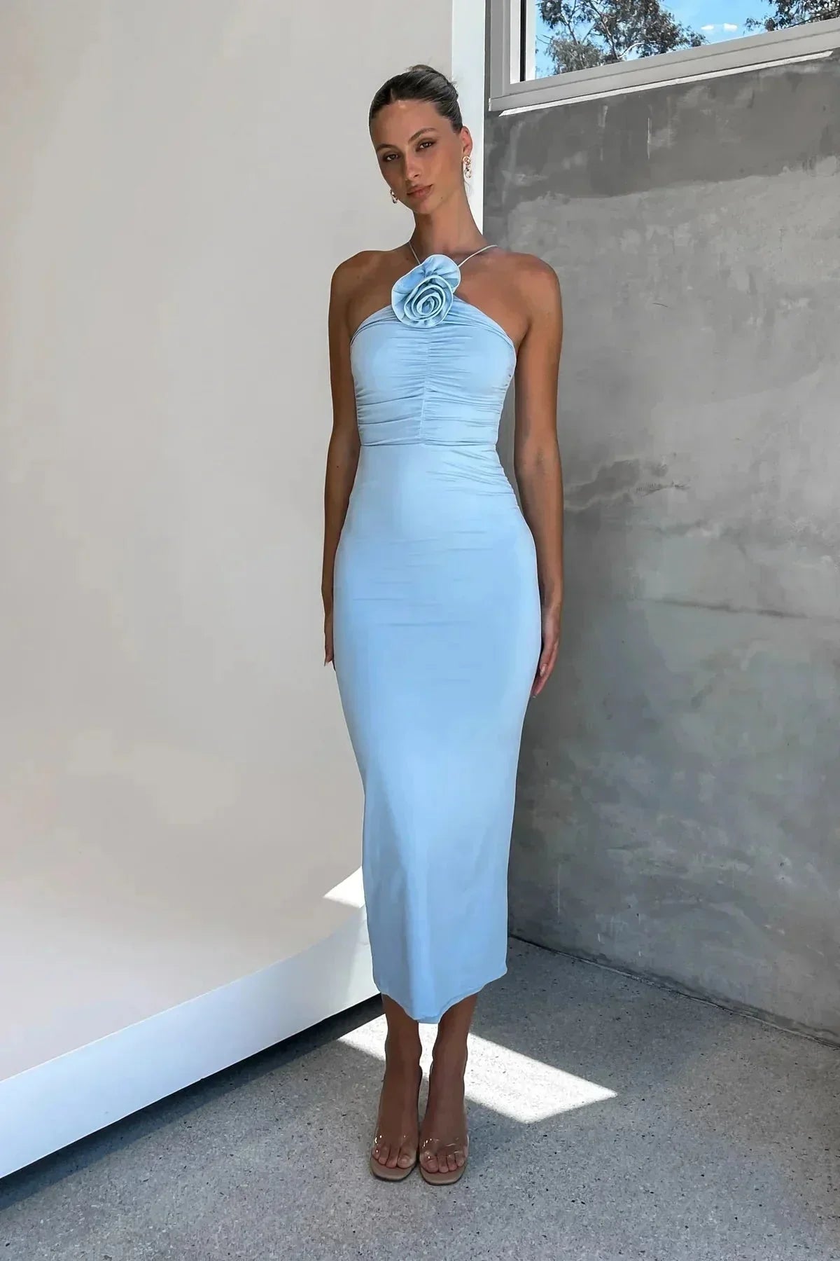 "Robe midi moulante en tissu doux, avec un col asymétrique sculptural et un motif floral délicat."