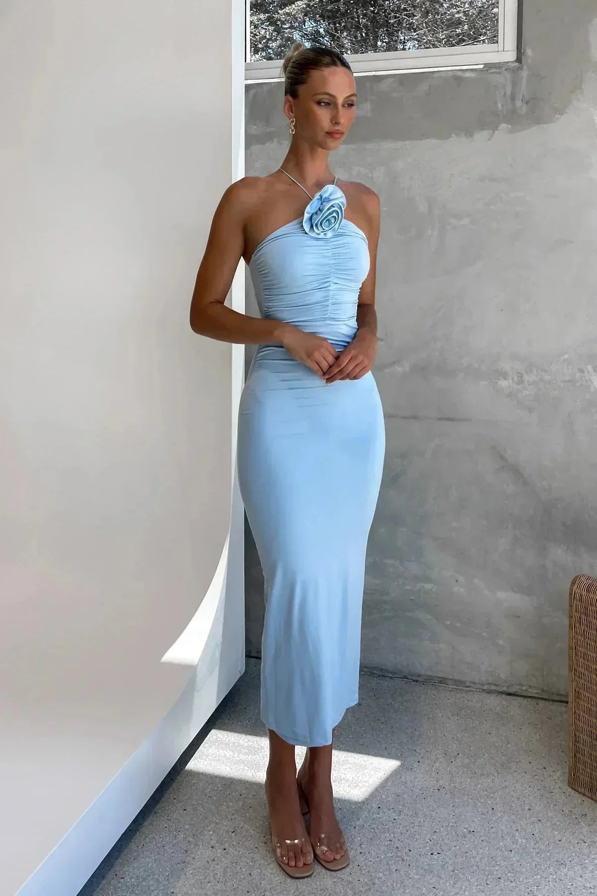 Robe midi moulante en tissu léger, avec des détails floraux et un col asymétrique sculptural pour une silhouette élégante.