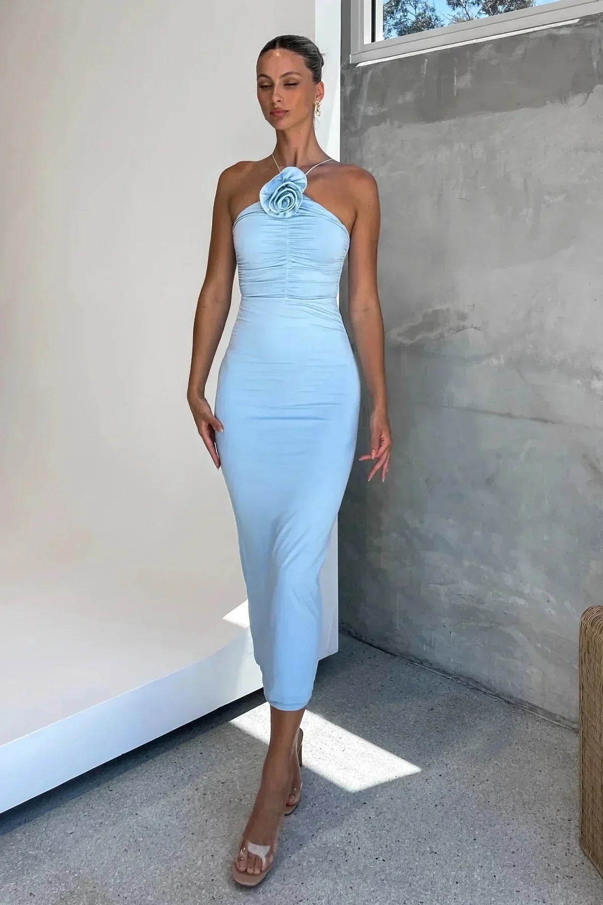 Robe midi moulante en tissu stretch, avec un col asymétrique sculptural et un motif floral délicat sur toute la surface.